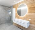 modern bathroom, gray tiles, white sink, large mirror, glass shower