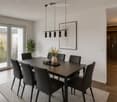 Modern dining room with a dark wooden dining table, six black chairs, a vase with flowers, a potted plant, a framed picture on the wall, and a sleek pendant light fixture. Large glass doors lead to a balcony with outdoor views.