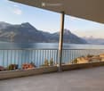 Balcony with a scenic mountain and lake view, featuring a metal railing and tiled floor.
