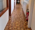 Hallway with tiled floor, white walls, wooden doors, windows, radiator, and a fire extinguisher.