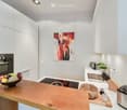 Modern kitchen with white cabinets, wooden counter, stainless steel appliances, and a bowl of fruit on the counter.