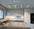 Modern kitchen with white cabinets, stainless steel sink, and built-in oven.