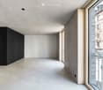 Minimalist unfurnished room with white walls, light wood paneling, and a large window leading to a balcony.
