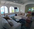 Living room with large arched windows, beige sofa, coffee table, and a floor lamp.