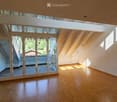 Completely empty room with wooden flooring, large glass sliding doors, and white walls.