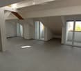 Open, modern loft-style space with concrete floors, white walls, large glass doors leading to a balcony, and a staircase leading to an upper level.