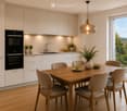 Modern kitchen with white cabinets, wooden dining table, six chairs, pendant light, and a view of greenery through a large window.