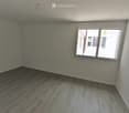 Empty room with wooden flooring and a single window, no furniture or equipment present.