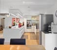 Modern kitchen with white cabinets, stainless steel appliances, island, and seating area.
