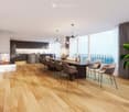 Modern dining area with a long wooden dining table, grey chairs, a fireplace, and a kitchen area with dark cabinets. Large windows offer a scenic view, complemented by a chandelier and decorative elements.
