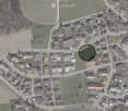 Suburban neighborhood with single family homes, some with solar panels, a playground, and roads.