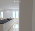 Modern kitchen with white cabinets, black countertop, island, dining area, pendant light, and multiple windows.