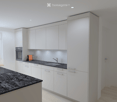 Modern kitchen with white cabinets, granite countertop, built-in oven, sink, and small appliances.