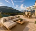 Balcony with a view of mountains and lake, featuring a sofa, coffee table, dining table, and chairs.