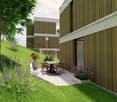 Outdoor patio area with a dining table and chairs, surrounded by greenery and flowers, adjacent to a modern house with wooden siding.