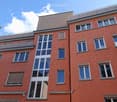 red brick apartment building, many windows, balconies