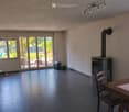 Bright living room with fireplace, large windows, and sliding glass doors leading to a patio.