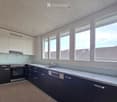 modern kitchen with white cabinets, marble counter top, stainless steel appliances, dishwasher, and windows.