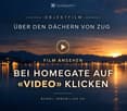 Promotional image for a real estate video, featuring a sunset over a body of water with city lights in the background. Text in German invites viewers to watch the video on Homegate.