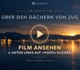 Promotional image for a real estate video titled "ÜBER DEN DÄCHERN VON ZUG" with a play button icon and sunset over water.