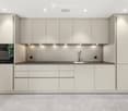 Modern kitchen with light-colored cabinets, a built-in oven, a sink with a modern faucet, and recessed lighting.
