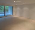 Empty room with light-colored tiled flooring, white walls, and large sliding glass doors leading to a balcony or terrace area.