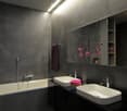 Modern bathroom with dark grey walls and black floor, featuring a bathtub, two white sinks, a large mirror, and a vase with pink flowers on the counter.
