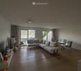 Modern living room with a large sectional sofa, coffee table, TV, and dining area with chairs and table, overlooking a scenic view.