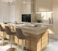 modern kitchen with island, wooden cabinets, marble countertops, black oven, faucet, stools, bottles, plants, and lamps