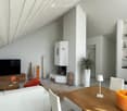Modern living room with white walls, wooden furniture, fireplace, large TV, and decorative items.