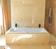 Luxurious bathroom with a large, freestanding bathtub, marble tiles, and a towel rack with a towel.