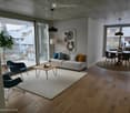 modern living room, white couch, coffee table, rug, large windows, balcony, view of the outside