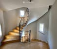 wooden staircase, wrought iron railing, tiled floor, white walls, windows