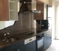 Modern kitchen with dark blue cabinets, stainless steel appliances, and a stone countertop.
