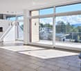 Bright, open living space with large glass doors leading to a balcony, tiled floor, fireplace, and built-in cabinetry.