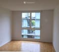 Empty room with wooden flooring and large sliding glass doors leading to a balcony area.