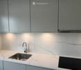 Modern kitchen with marble countertops, stainless steel sink, and built-in induction cooktop.