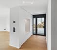 Empty room with white walls, wooden floor, and a built-in closet with a mirrored sliding door leading to an outdoor area.