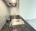 Modern kitchen with granite countertop, stainless steel sink, and sleek faucet.