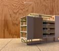3D model of a multi-story building with balconies, green supports, and a modern design.