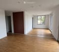 Empty room with wooden flooring, white walls, and a large window. A built-in wardrobe is visible on one wall.