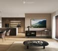 Modern open-plan kitchen and dining area with wooden flooring, dark wooden cabinets, a central island, and a dining table with chairs. Features include a large TV screen, pendant lights, a coffee table with books and a cup, and a potted plant near the win