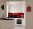 Modern kitchen with white cabinets, red backsplash, stainless steel appliances, and decorative items including a vase and clock.