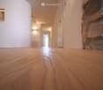 wooden floor, white walls, hallway, recessed lighting, stone pillar