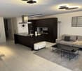 Modern open-plan living and dining area with a grey sofa, coffee table, bench, dining table, and chairs. The kitchen features dark cabinets, a stainless steel range hood, and a central island with a sink and faucet. A large mirror and clock are mounted on