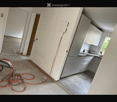Empty room with unfinished walls and floor, visible electrical wiring, and a small kitchen area with cabinets and sink.