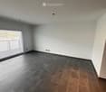 Empty room with grey and brown tiled floor, white walls, large window with blinds, and recessed lighting.
