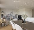 Modern living and dining area with a large abstract mural, a chandelier, a sofa, a dining table with chairs, and decorative vases.