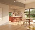 Open-plan living and dining area with a modern kitchen island, dining table, sofa, and large windows overlooking greenery.