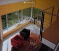 large windows, balcony, black and red chairs, chandelier, coffee table